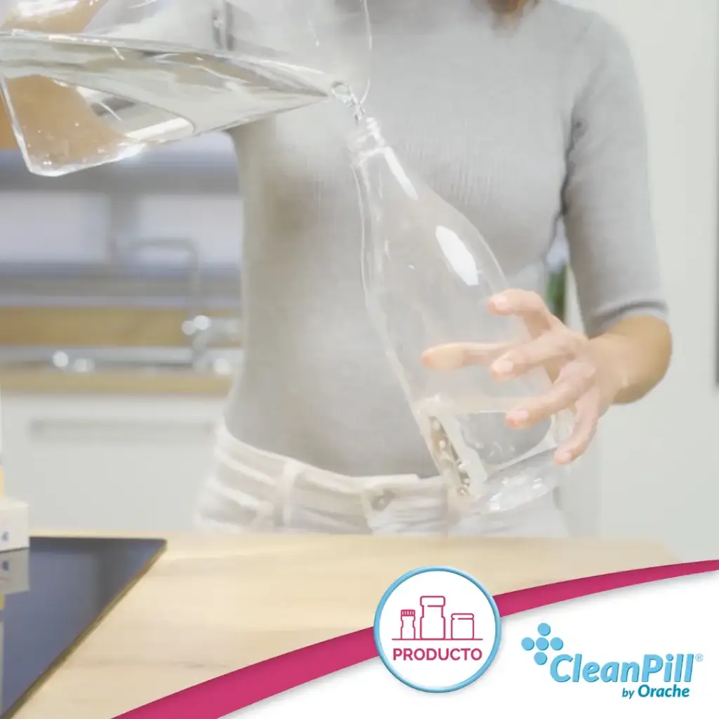 Añadiendo agua a una botella reutilizable para preparar CleanPill Refill